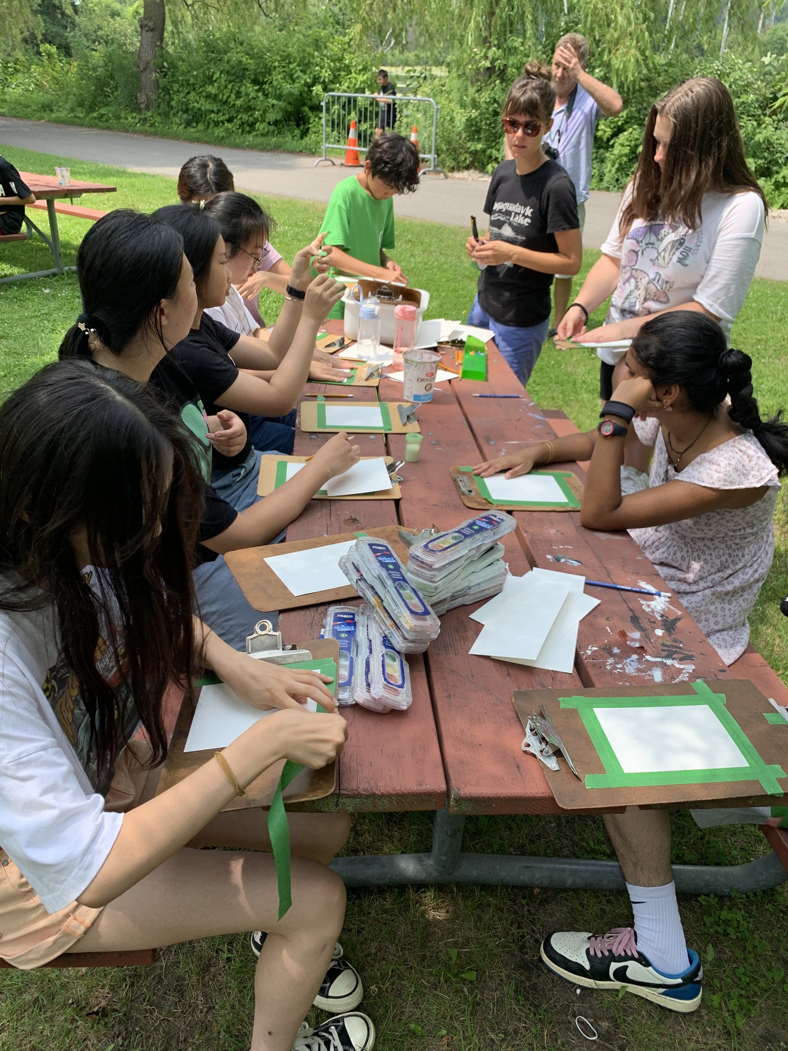 Students sitting at picnic table outside doing crafts and art projects Open Gallery